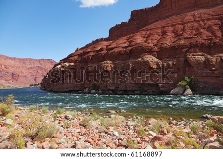 Cold green water of the Colorado River in the red rocks of the desert