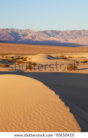 The famous Death Valley in California. Sand dunes and ancient mountains. Pink sunrise