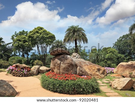 Tropical park  and artly decorated flower beds. Huge picturesque landscape park in Thailand.