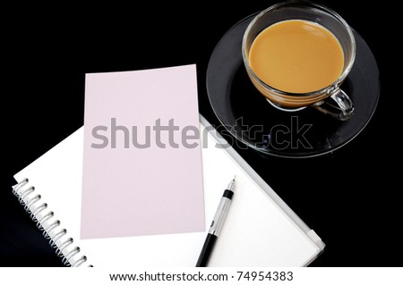 clear cup of coffee on dark background with blank paper