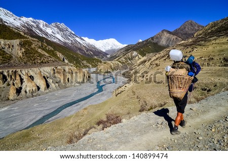 Mountain porter carrying heavy load in Himalayas, Nepal