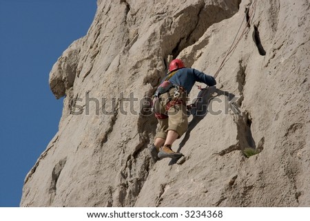 Rock climber on a grey rock wall