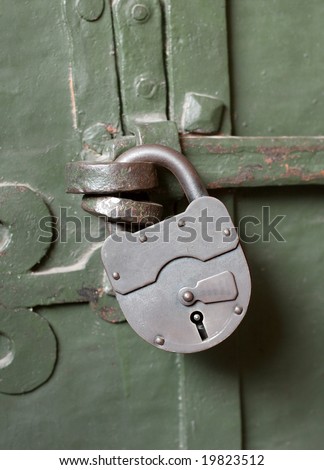 Big padlock on a green metal gate
