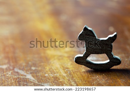 Loneliness concept: wooden rocking horse on wooden background