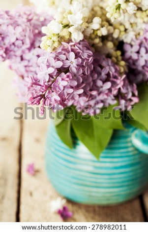 Brunches of white and purple lilac in vase