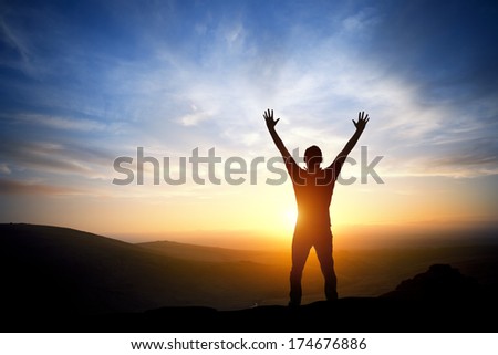 Fresh New Morning - A person reaching up on a bright morning sunrise.