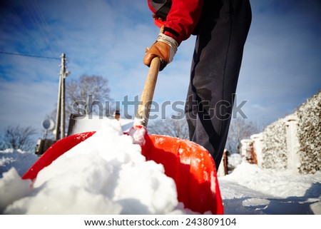 Man with snow shovel cleans sidewalks in winter. Winter time. Latvia. Europe.