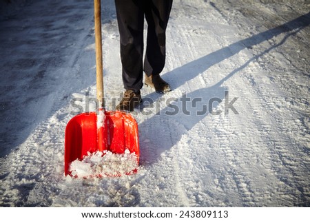 Man with snow shovel cleans sidewalks in winter. Winter time. Latvia. Europe.