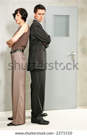 elegant couple standing back to back in a room