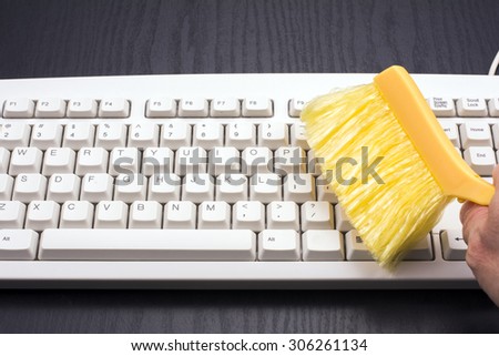 Dust of computer keyboard are cleaning with a brush