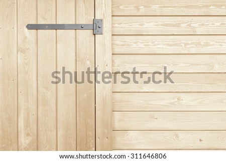 The vertical and horizontal lines of wooden planks with iron hinges for doors