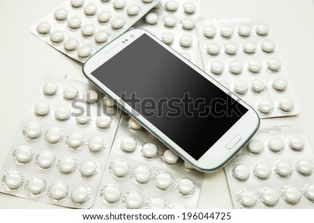 Medical smartphone. A modern cellphone with pills.