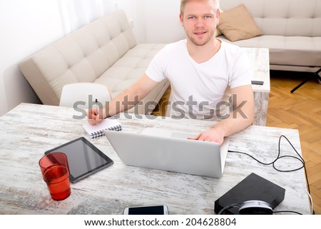 A young caucasian man working in his home office.