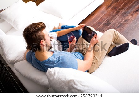 Young couple using a Tablet PC together on the Sofa at home.
