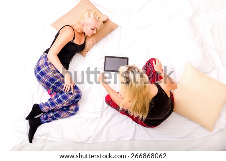 Mother and Daughter enjoying a Pyjama party with a Tablet PC.