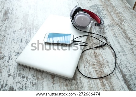 Headphones connected to a smartphone and a Laptop computer.