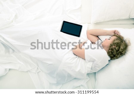 A young plus size woman sleeping in Bed with a Tablet PC.