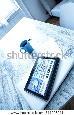 Stock market trading and research software on a Tablet PC on a office Desktop with a Laptop computer.