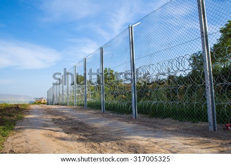 ROESZKE, HUNGARY - SEPTEMBER 15: View on the 175km long fence between Hungary and Serbia installed due to the Refugee crisis on September 15, 2015 in Roeszke, Hungary.