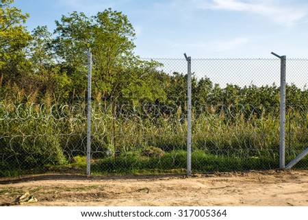 ROESZKE, HUNGARY - SEPTEMBER 15: View on the 175km long fence between Hungary and Serbia installed due to the Refugee crisis on September 15, 2015 in Roeszke, Hungary.