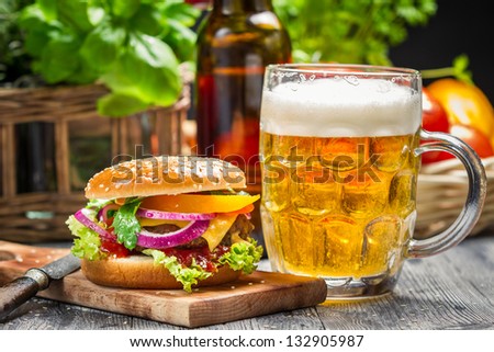 Closeup of fresh burger and a cold beer