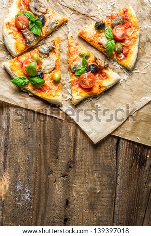 Fresh pizza on paper and old wooden table as background 2