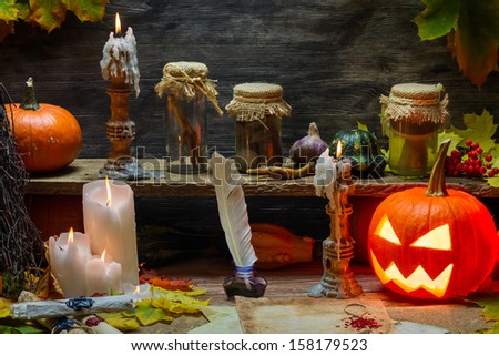 Pumpkin, old scrolls and candles in witch\'s cottage