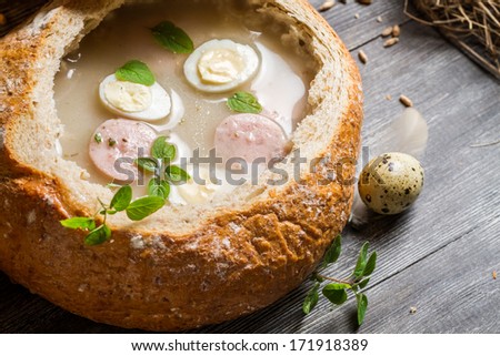 Closeup of soup served in bread with sausage and egg