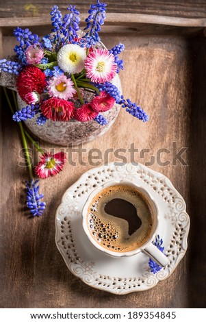 Coffee and spring flowers on old wooden tray