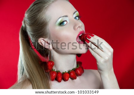 Creative makeup beauty shot of model with strawberries, passion and desire