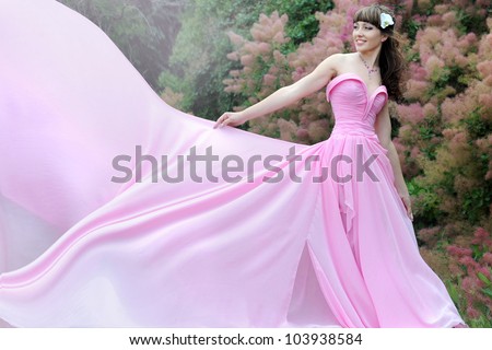 Beautiful slim woman in a long pink dress. Bride