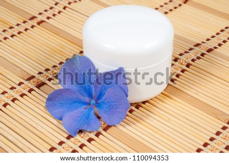 Cream for face and flower on a bamboo