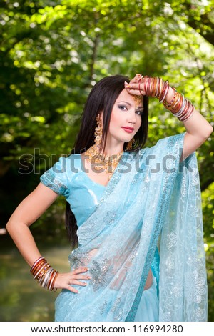 Beautiful young indian woman in traditional clothing with bridal makeup and jewelry. brunette bride traditionally dressed in India. Girl bollywood dancer in Sari.