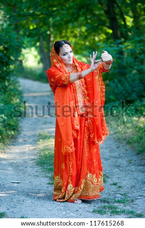 Beautiful young indian woman in traditional clothing with bridal makeup and jewelry. Bride traditionally dressed in India. Girl bollywood dancer in Sari.
