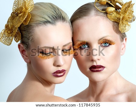 women with gold make up and gold orchid in hair
