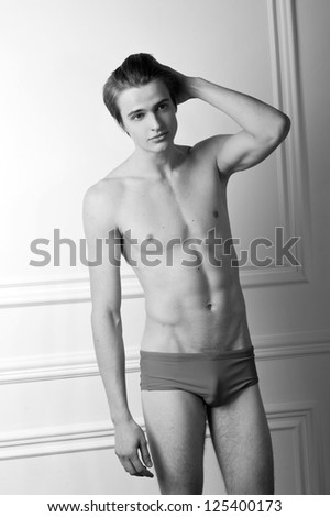 sexy male fitness model in brief shorts. Black-and-white photo.