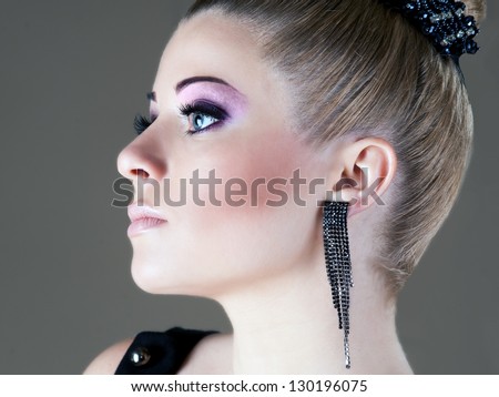 Closeup beauty portrait of attractive model face with bright visage. Violet eye makeup and pink lips make-up. Evening style.