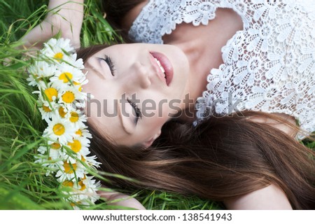 Beautiful  smiling young girl outdoors in spring. Wreath of daisies