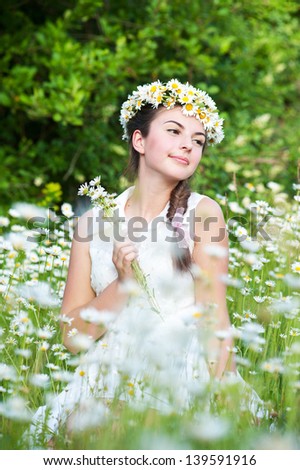 Beautiful woman enjoying daisy field, pretty girl relaxing outdoor, having fun, holding plant, happy young lady and spring green nature, harmony concept