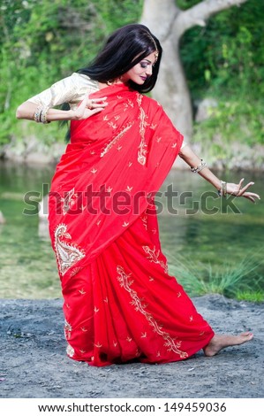 Beautiful young indian woman in traditional clothing with bridal makeup and jewelry. gorgeous brunette bride traditionally dressed in India. Girl bollywood dancer in Sari and henna on hands