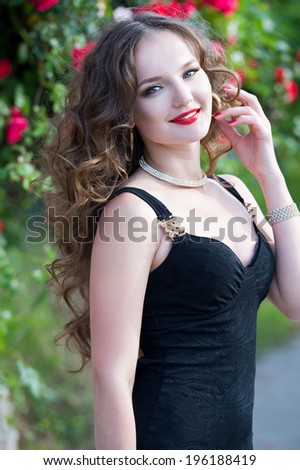 Beautiful woman in the garden of  roses