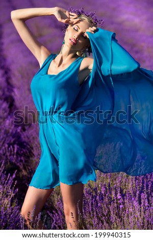 Beautiful girl in on the lavender field. Young woman with long hair collects lavender