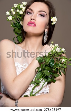 Beautiful woman with curly hair and roses. Beautiful bride.