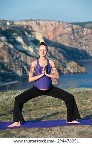 Pregnant woman practicing yoga outdoor