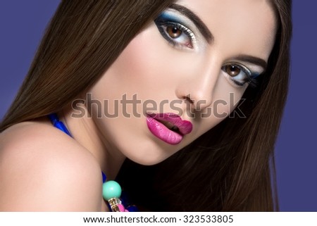 Beautiful woman face with colorful make-up and pink lips. Woman with jewelry.