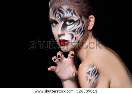 Halloween make up. Woman with tiger face in halloween concept.