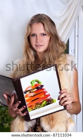 Young woman in restaurant is reading menu
