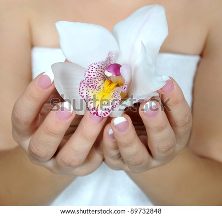 Hands with orchid flower.Beautiful nails