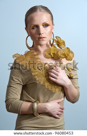 Vogue style portrait of a woman with gold makeup