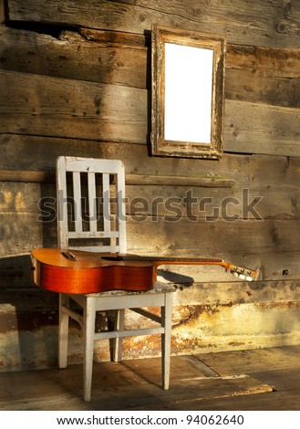 blues guitar on an old wooden chair at the wall with empty frame